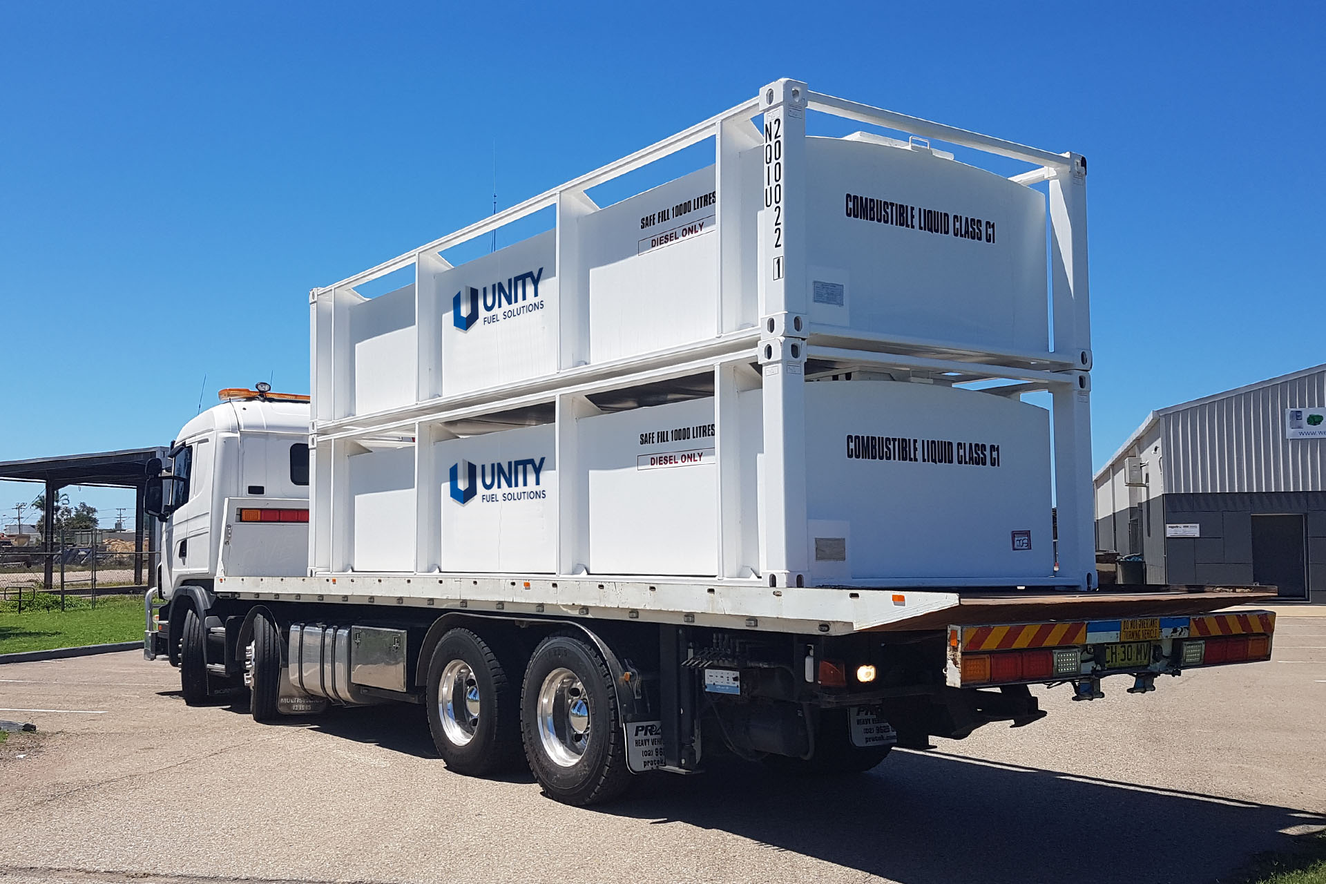 Truck delivering fuel storage tanks for wholesale fuel distributors